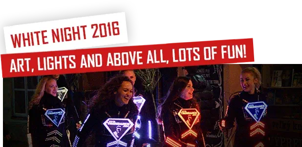 White Night 2016 – Art, lights and above all, lots of fun! – smiling dancers in black LED suits with glowing Tron Dance logo signs on their chests, on a street at night
