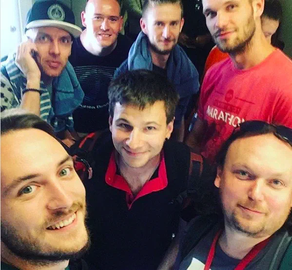 Selfie of our team – seven smiling young men, some of them with backpacks – travelling to Karachi
