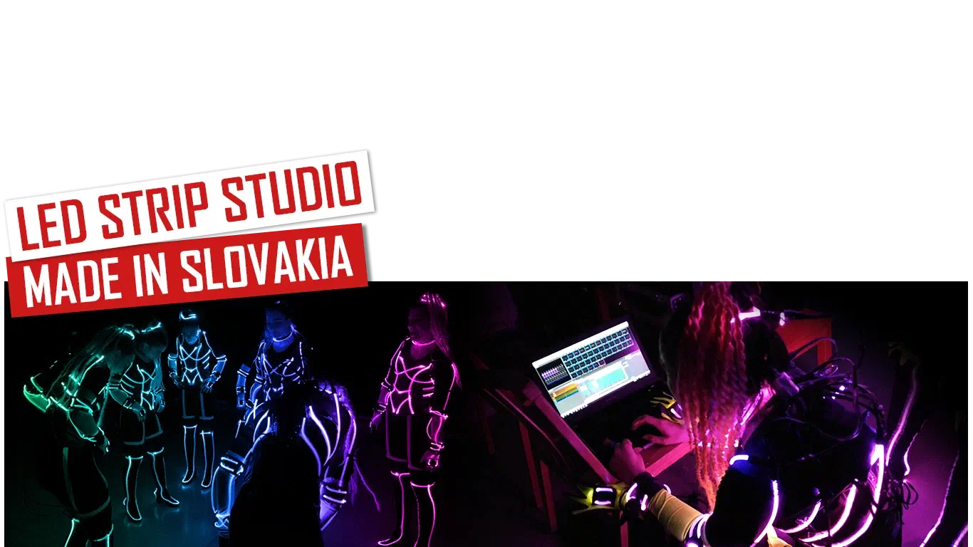 LED Strip Studio – Made in Slovakia – red and white banners above Tron dancers in glowing LED suits and a dancer programming the show on a laptop