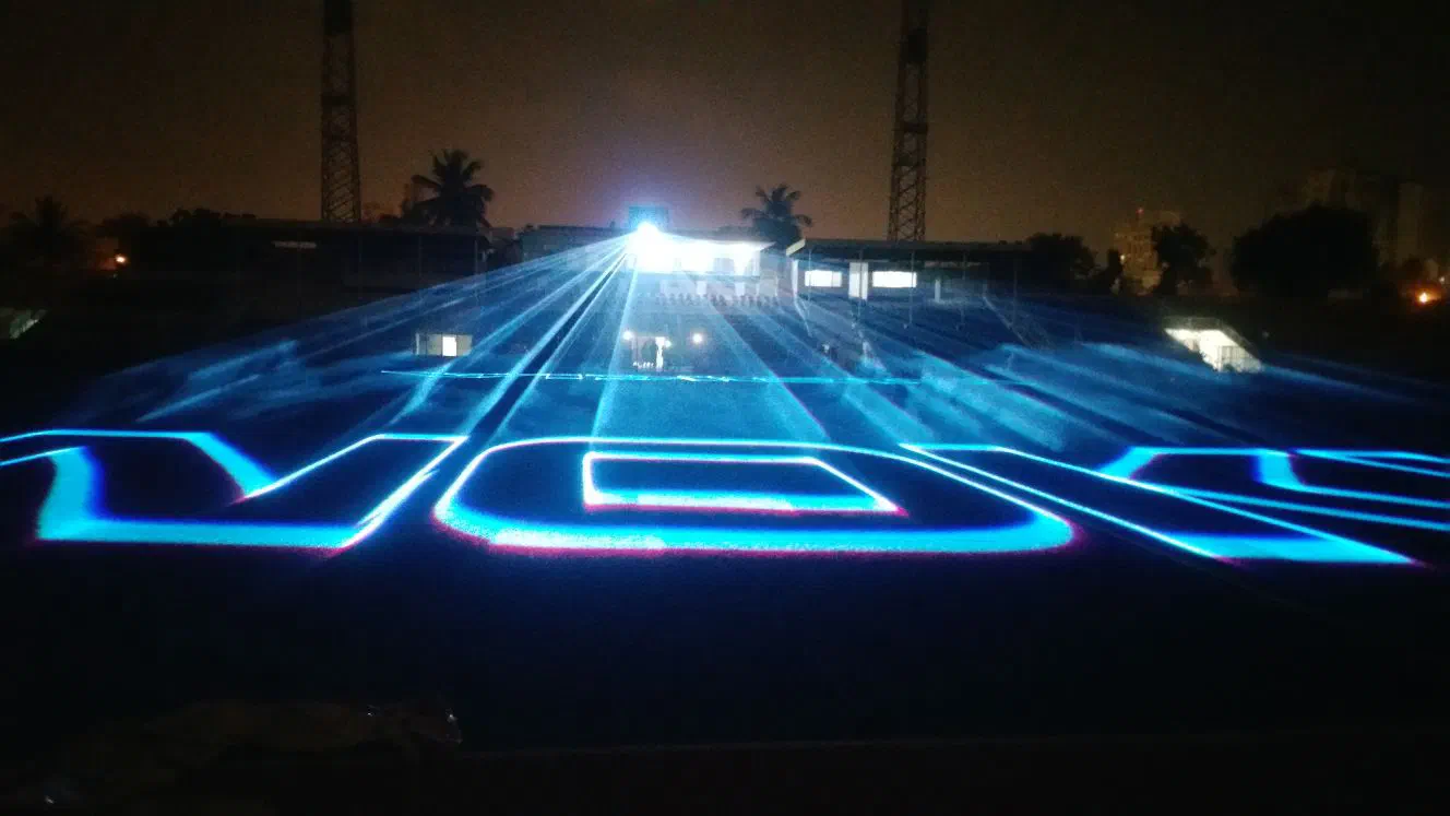 The Nokia logo drawn by blue laser beams across the dark stadium pitch at night