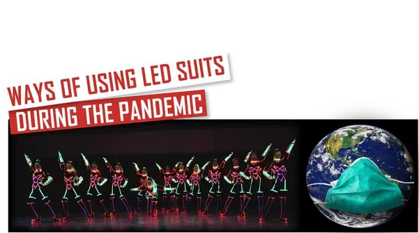 Ways of using LED suits during the pandemic – red and white banner above a row of dancers with green UV face paint in LED costumes glowing pink, orange and green on a dark stage, next to the Earth wearing a green face mask