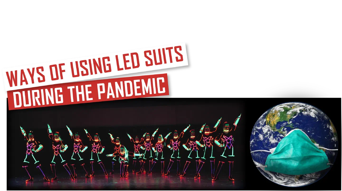 Ways of using LED suits during the pandemic – red and white banner above a row of dancers with green UV face paint in LED costumes glowing pink, orange and green on a dark stage, next to the Earth wearing a green face mask
