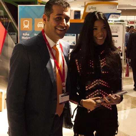 Girls in glowing LED suits handing out invitations and posing for pictures and selfies with visitors at the exhibition in Dubai – photo 1