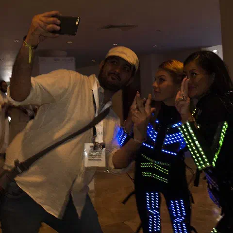 Girls in glowing LED suits handing out invitations and posing for pictures and selfies with visitors at the exhibition in Dubai – photo 2