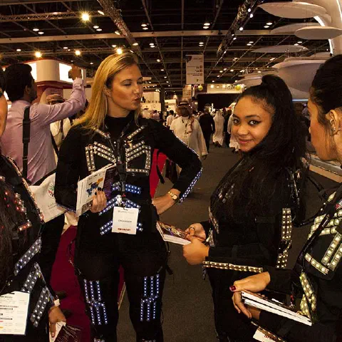 Girls in glowing LED suits handing out invitations and posing for pictures and selfies with visitors at the exhibition in Dubai – photo 5