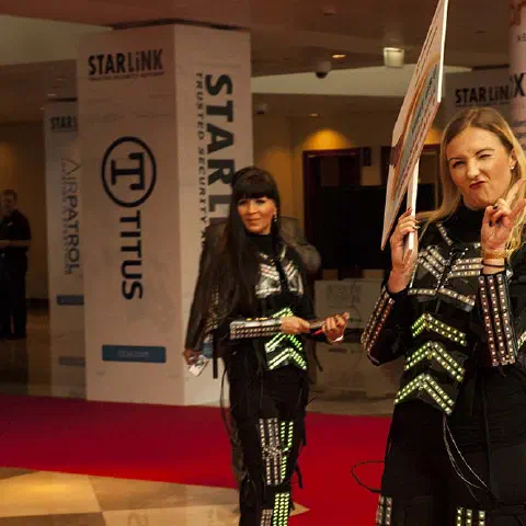 Girls in glowing LED suits handing out invitations and posing for pictures and selfies with visitors at the exhibition in Dubai – photo 7
