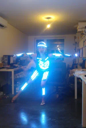 Dancer in the new LED costume with glowing blue LED strips on the helmet, chest, arms and legs, posing in our office