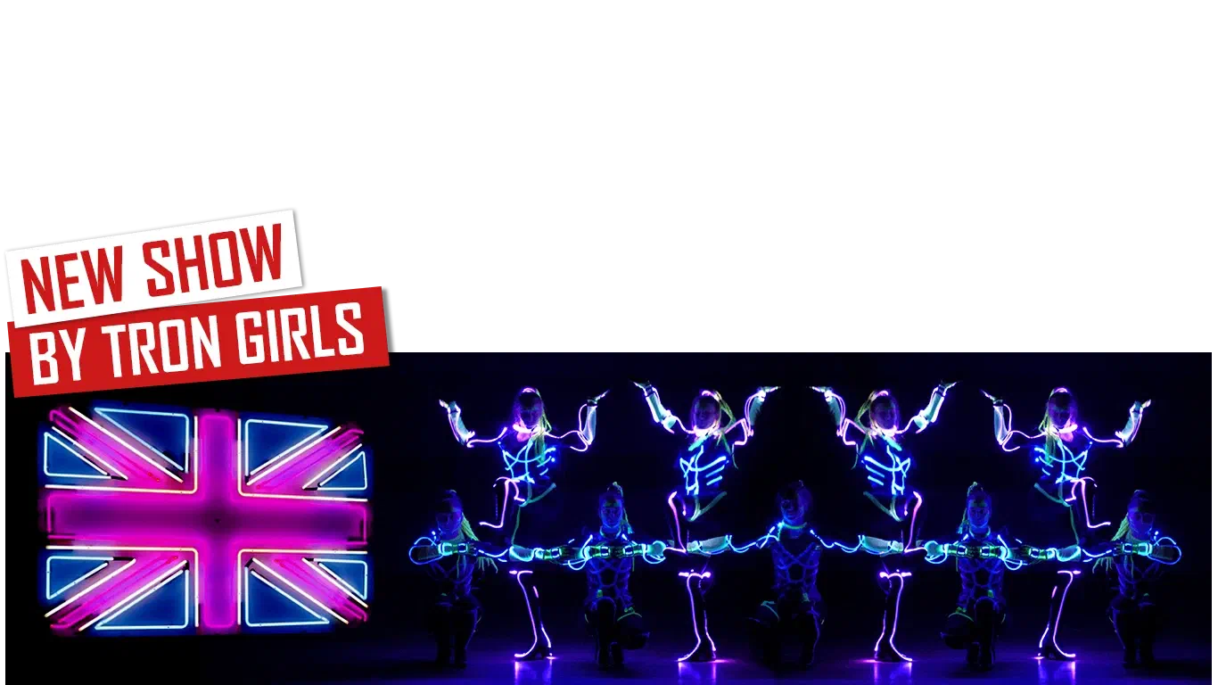 New show by Tron Girls – red and white banners above a neon Union Jack and Tron Girls in glowing blue and pink LED costumes posing in a mirrored line on a dark stage