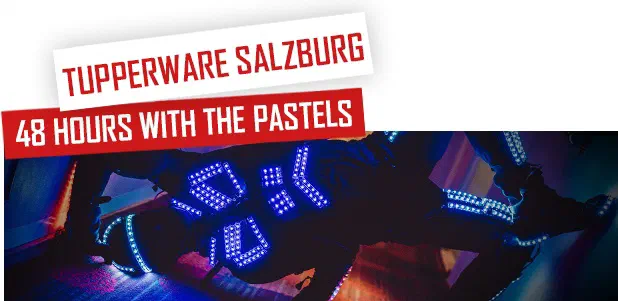 Tupperware Salzburg – 48 hours with The Pastels – red and white banners above a Tron dancer in an LED suit glowing blue