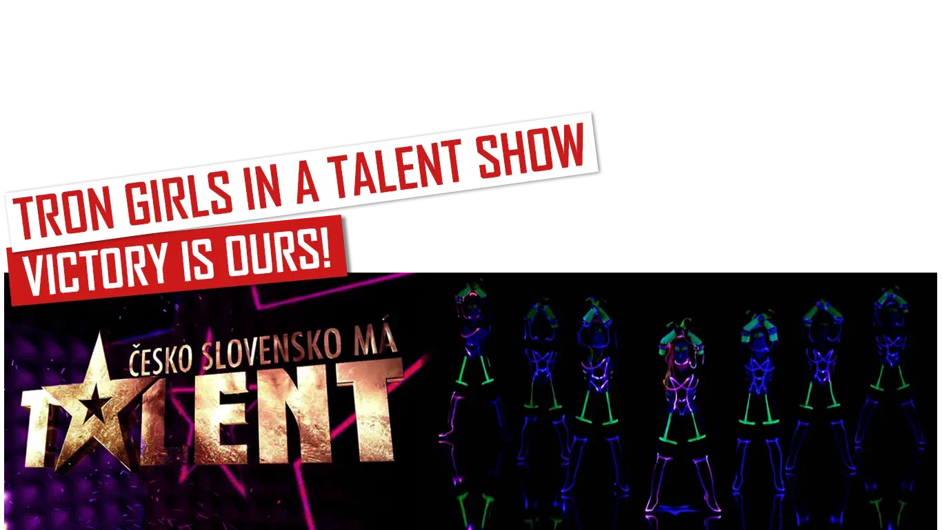 Tron Girls in a talent show – Victory is ours! – red and white banners above the gold Česko Slovensko má talent logo and seven Tron Girls in glowing blue, green and pink LED & UV costumes
