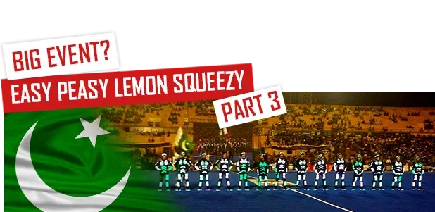 Big event? Easy peasy lemon squeezy – Part 3 – Tron dancers in glowing LED suits lined up on a stadium pitch, next to the flag of Pakistan