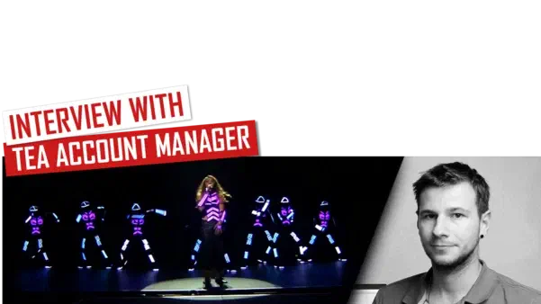 Interview with TEA Account Manager – red and white banners above Tron dancers in glowing purple and blue LED suits around a singer on a dark stage, next to a black-and-white portrait of Richie