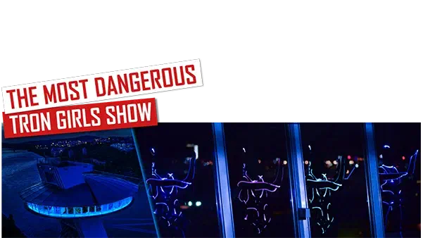 The most dangerous Tron Girls show – red and white banners above the UFO bridge in Bratislava lit in blue at night and Tron Girls in glowing blue and purple LED suits behind its windows