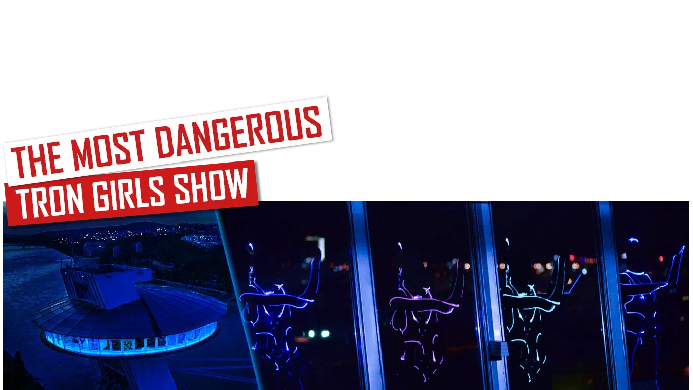 The most dangerous Tron Girls show – red and white banners above the UFO bridge in Bratislava lit in blue at night and Tron Girls in glowing blue and purple LED suits behind its windows