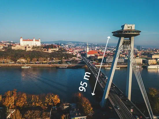 The UFO bridge over the Danube in Bratislava on a sunny autumn day, with Bratislava Castle on the hill behind it and an arrow marking the 95 m height of the UFO