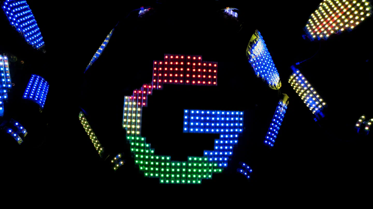 Close-up of a pixel LED suit chest showing a large letter G in red, yellow, green and blue pixels, with blue and yellow pixel panels around it