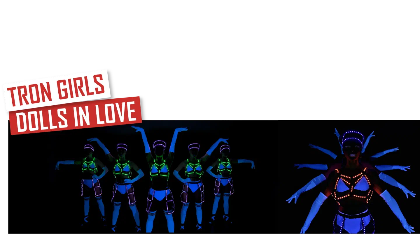 Tron Girls – Dolls in love – red and white banners above a line of five Tron Girls in white costumes glowing blue under UV light with green and pink LED harnesses, next to a close-up of a dancer in an orange LED harness with white-gloved arms fanned out behind her