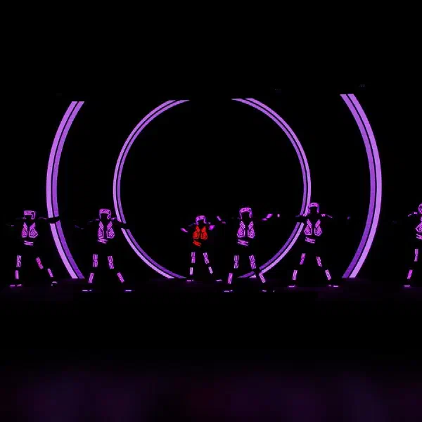 Tron Dance Gen II: seven LED dancers glowing violet, one in red, before concentric purple circles on the LED screen