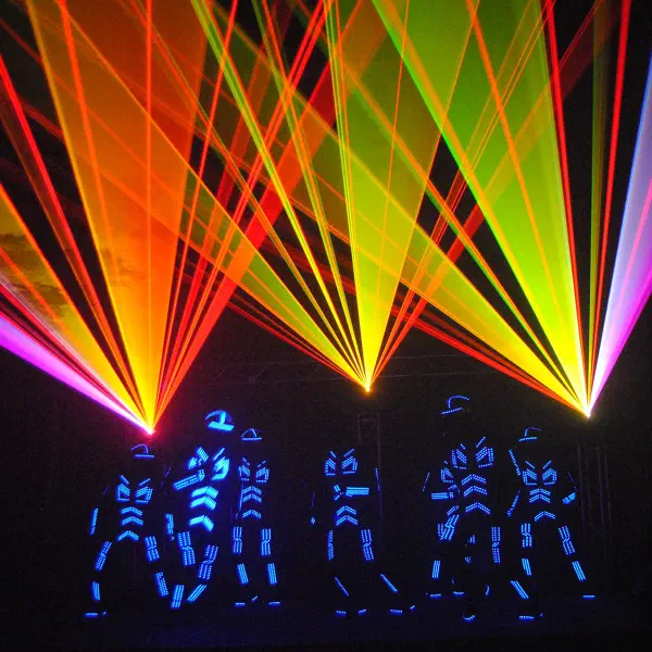 Tron Dance: six dancers in blue LED suits under fans of orange, yellow and pink laser beams on stage