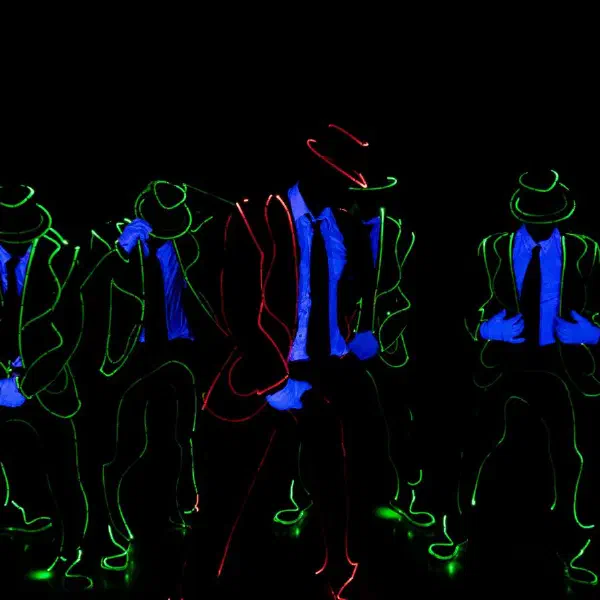 Tron Man: six dancers in green light-wire suits and fedoras, one outlined in red, with UV-blue gloves and shirts