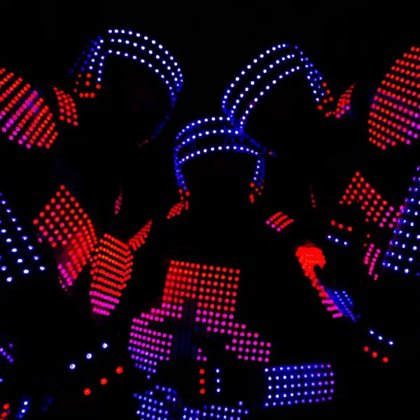 Tron Pixel Show: detail troch pixelových LED tanečníkov v červenom, ružovom a modrom pixelovom kostýme tesne pri sebe
