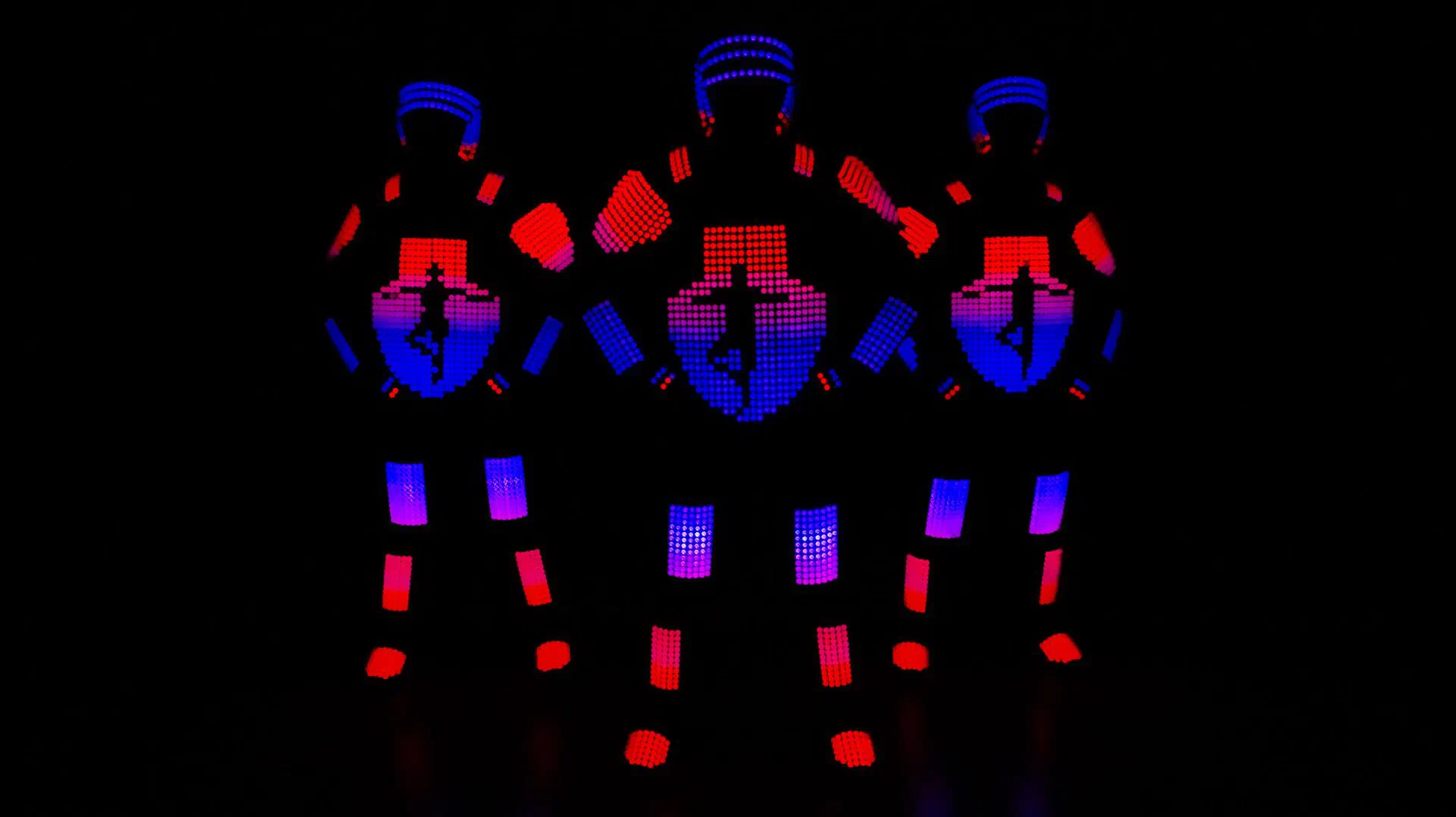 Traja LED tanečníci Tron Pixel Show v pixelových kostýmoch s logom Tron Event Agency na hrudi v červenom a modrom svetle