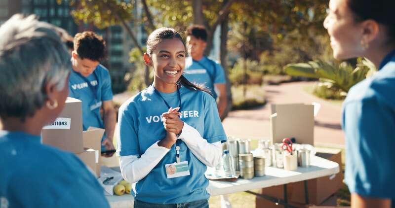 Smiling young woman wearing a volunteer t-shirt at an outdoor community event