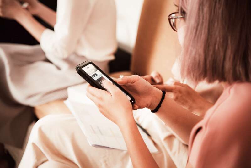 Woman using a smartphone while attending a workshop, highlighting the use of digital tools and apps in modern event planning